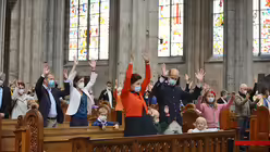 Beim "Vater unser" schauen sich Eltern und Kinder die Gesten von Schulseelsorger Hofer ab. / &copy; Beatrice Tomasetti (DR)