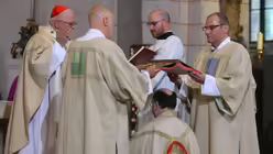 Bertram Meier kniet w&auml;hrend der Bischofsweihe im Dom unter dem Evangelium / &copy; Karl-Josef Hildenbrand (dpa)