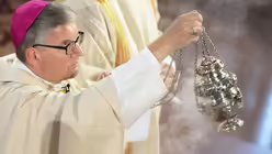 Bischof Kohlgraf schwenkt das Weihrauchfass. / &copy; Arne Dedert (dpa)