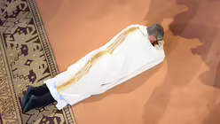 Peter Kohlgraf liegt w&auml;hrend der Litanei am Boden. / &copy; Arne Dedert (dpa)