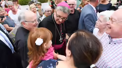 Bischof Kohlgraf (M) nimmt nach seiner Amtseinf&uuml;hrung vor dem Dom in Mainz ein Bad in der Menge. / &copy; Arne Dedert (dpa)