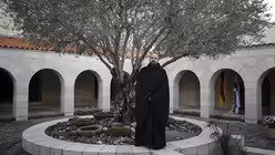 Pater Basilius Schiel im Atrium der Brotvermehrungskirche / &copy; Corinna Kern (dpa)