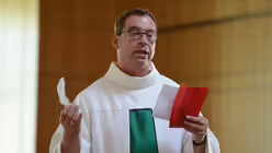 Burkhard Hofer hat für jedes Kind ein "Segenstütchen" mit einer Feder und einem Segensbändchen / © Beatrice Tomasetti (DR)