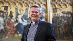 Domkapitular Dr. Dominik Meiering vor dem Altar der Stadtpatrone von Stefan Lochner im K&ouml;lner Dom. / &copy; Beatrice Tomasetti (DR)