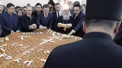 Der serbisch-orthodoxe Patriarch Irinej (wei&szlig;e Kopfbedeckung) h&auml;lt das Weihnachtsbrot  / &copy; Darko Vojinovic (dpa)