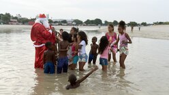 Der Weihnachtsmann verteilt Geschenke an Kinder in Rio de Janeiro, Brasilien  / ©  Fabio Teixeira (dpa)