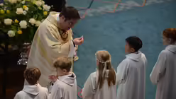 Domvikar Tobias Hopmann teilt die Kommunion aus / © Beatrice Tomasetti (DR)