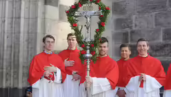 Dommessdiener mit dem palmengeschm&uuml;ckten Kreuz vor der Minoritenkirche. / &copy; Tomasetti (DR)