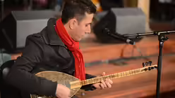 Der syrische Fl&uuml;chtling Massud Sulaiman tr&auml;gt ein Wiegenlied aus seiner Heimat vor. / &copy; Tomasetti (DR)