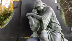 Ein klassisches Motiv: Frau mit Urne in Trauer versunken. / © Beatrice Tomasetti (DR)