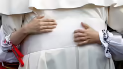 Ein M&auml;dchen umarmt Franziskus in Iasi / &copy; Andrew Medichini (dpa)