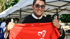 Ein Priester hält ein T-Shirt mit dem Logo des WJT / © Gennari/Siciliani (KNA)