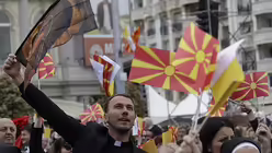 Ein Priester schwenkt eine Flagge, um Papst Franziskus bei seiner Ankunft zur Messe zu begrüßen / © Alessandra Tarantino (dpa)