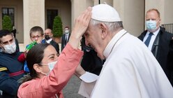 Eine Frau legt ihre Hand auf den Kopf von Papst Franziskus bei einer Generalaudienz am 19. Mai 2021 / © Vatican Media/Romano Siciliani (KNA)