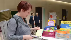 Eine Konventsteilnehmerin interessiert sich f&uuml;r Kinderb&uuml;cher. / &copy; Beatrice Tomasetti (DR)