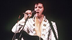  Ein Archivfoto aus dem Jahr 1973 zeigt Elvis Presley bei einem Konzert auf der Bühne.  / © Anonymous (dpa)