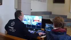 Firmling Robin Kraus schaut Informatiker Frank Dietz &uuml;ber die Schulter.  / &copy; Beatrice Tomasetti (DR)