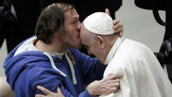 Franziskus wird während der wöchentlichen Generalaudienz von einem Gläubigen auf die Stirn geküsst. / © Giuseppe Ciccia (dpa)