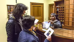 Ankunft im G&auml;stehaus Casa di Santa Brigida. Schwester Gertrude reicht zwei deutschen G&auml;sten an der Rezeption Informationsbrosch&uuml;ren, auf dem Tresen liegen Zimmerschl&uuml;ssel, an der Wand h&auml;ngt ein Kruzifix. (KNA)