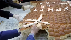 Gläubige zerbrechen in Belgrad das traditionelle Weihnachtsbrot / © Darko Vojinovic (dpa)
