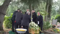 Grabträger lassen einen Sarg in die Erde. / © Beatrice Tomasetti (DR)