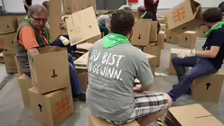 Freiwillige Helfer falten die traditionellen Papphocker / © Jürgen Blume (epd)