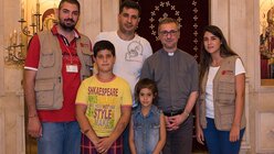Erzbischof Heße (2.v.r.) mit Caritas-Mitarbeitern bei einer christlichen Flüchtlingsfamilie / © Elisabeth Schomaker (KNA)