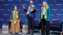 Amy Kirchhoff (l-r), Generalsekret&auml;rin der Bundessch&uuml;lerkonferenz, Bundeskanzler Friedrich Merz (CDU) und Lisa Quarch, Geistliche Leiterin Bund der Deutschen Katholischen Jugend, nehmen beim 104. Deutschen Katholikentag in W&uuml;rzburg unter dem Motto "Gemeinsam Zukunft gestalten" an einer Podiumsdiskussion teil / &copy; Matthias Schrader/AP Pool (dpa)