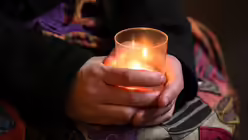 Hände halten ein Teelicht beim Nightfever Abendgebet (KNA)