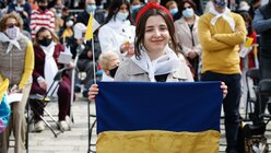 Eine junge Frau hält eine ukrainische Nationalflagge und lächelt bei einer Messe mit Papst Franziskus in Floriana (Malta) / © Paul Haring (KNA)