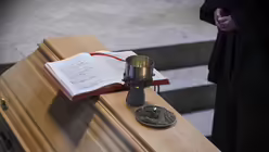 Sarg von Franz Kamphaus, emeritierter Bischof von Limburg, mit Kelch und Evangeliar im Chorraum des Hohen Dom zu Limburg am 5. November 2024 in Limburg. / © Harald Oppitz (KNA)