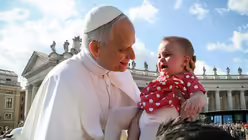 Papst Leo XIV. segnet ein Baby vor seiner Amtseinführung auf dem Petersplatz / © Romano Siciliani (KNA)