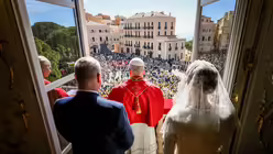 F&uuml;rst Albert II. und F&uuml;rstin Charl&egrave;ne von Monaco stehen hinter Papst Leo XIV., als er die Menschen begr&uuml;&szlig;t, am Fenster des F&uuml;rstenpalasts in Monaco / &copy; Vatican Media/Romano Siciliani (KNA)