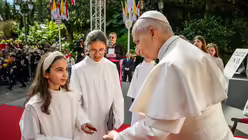 Zwei M&auml;dchen in wei&szlig;en Gew&auml;ndern stehen vor Papst Leo XIV. bei einer Begegnung mit Jugendlichen am 28. M&auml;rz 2026 vor der Kirche Sainte D&eacute;vote in Monaco / &copy; Vatican Media/Romano Siciliani (KNA)