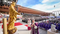 Papst Leo XIV. steht vor einer goldenen Marienstatue beim Gottesdienst am 28. M&auml;rz 2026 im Stadion Louis II. in Monaco / &copy; Vatican Media/Romano Siciliani (KNA)