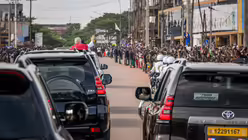 Papst Leo XIV. gr&uuml;&szlig;t am 15. April 2026 aus dem fahrenden Auto die Menschen am Stra&szlig;enrand in Yaound&eacute; (Kamerun) / &copy; Vatican Media/Romano Siciliani (KNA)