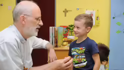 Auch das Gespräch mit den Kleinsten - im wahrsten Sinne des Wortes auf Augenhöhe - gehört zum Alltag von Weihbischof Puff. (Archivbild) / © Beatrice Tomasetti (DR)