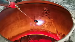 Ausschmelzen der Verzierungen aus Wachs im Glockenmantel (Glockengießerei Grassmayr)