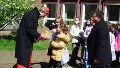 Eines der j&uuml;ngsten Chormitglieder &uuml;berreicht Kardinal Woelki ein Osterei aus Schokolade / &copy; Beatrice Tomasetti (DR)