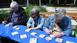 Zu den Angeboten am Nachmittag gehört auch, Holztafeln mit dem Schriftzug "Würde unantastbar" auszumalen.

 / © Beatrice Tomasetti (DR)