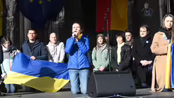 Bei einer Schweigeminute mit der ukrainischen Sängerin Kristine Shon gehen alle auf die Knie