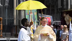 Domkapitular Ohly teilt am Fronleichnamstag die Kommunion auf dem Roncalliplatz aus. / © Beatrice Tomasetti (DR)