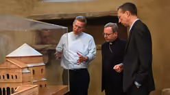 Der Hausherr von St. Gereon, Pfarrer Dominik Meiering, erläutert dem Gast aus Limburg das Kirchengebäude anhand eines Modells. / © Beatrice Tomasetti (DR)