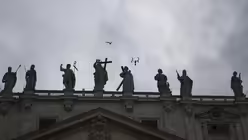 Eine Möwe und eine Drohne fliegen über dem Petersdom am zweiten Tag des Konklaves (dpa)