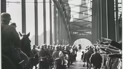 Menschen zeigen den Hitlergru&szlig;, w&auml;hrend Soldaten der Wehrmacht auf den K&ouml;lner Dom zumarschieren. (NS DOK)