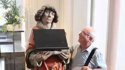 DOMRADIO.DE Diakon Willibert Pauels steht neben einer Figur, die ebenfalls einen Diakon darstellen soll. / © Oliver Kelch (DR)