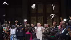 Kamerun, Bamenda: Papst Leo XIV. (M) l&auml;sst neben dem Erzbischof von Bamenda, Andrew Nkea Fuanya (M links), am Ende eines Friedenstreffens in der Kathedrale St. Joseph mit der &ouml;rtlichen Gemeinde wei&szlig;en Tauben fliegen / &copy; Andrew Medichini/AP (dpa)