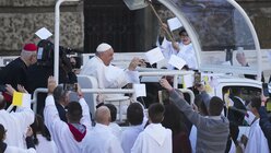 Papst Franziskus kommt im Papamobil zu einer Heilige Messe. / © Andrew Medichini/AP (dpa)