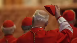 Ein Kardinal hält im Petersdom sein Zucchetto nach der Ankunft der Prozession mit dem Leichnam von Papst Franziskus / © Francisco Seco/AP (dpa)