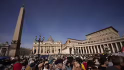 Menschen warten auf dem Petersplatz / © Andreea Alexandru/AP (dpa)